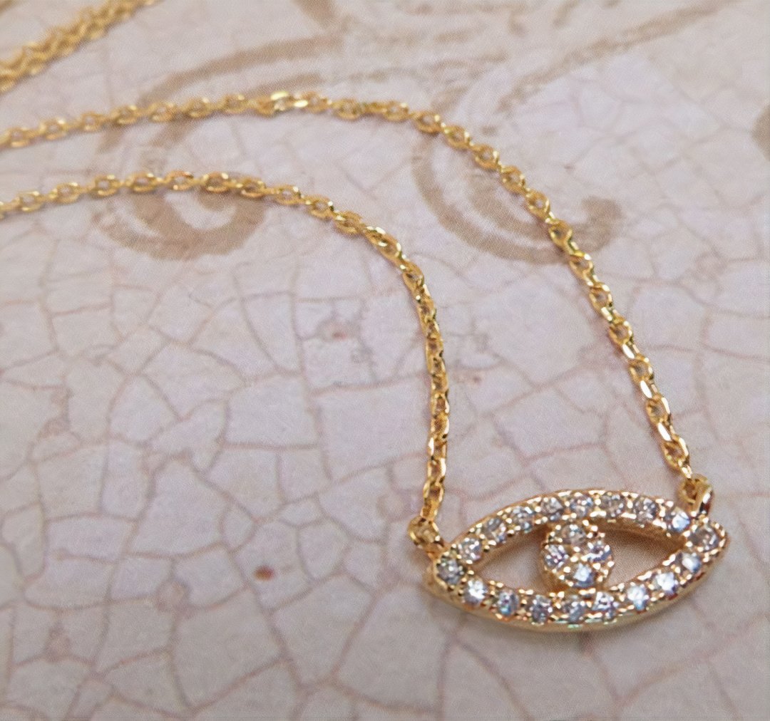 18K gold Abby necklace by Whacky Wino featuring a delicate chain and pendant, displayed against a neutral background.